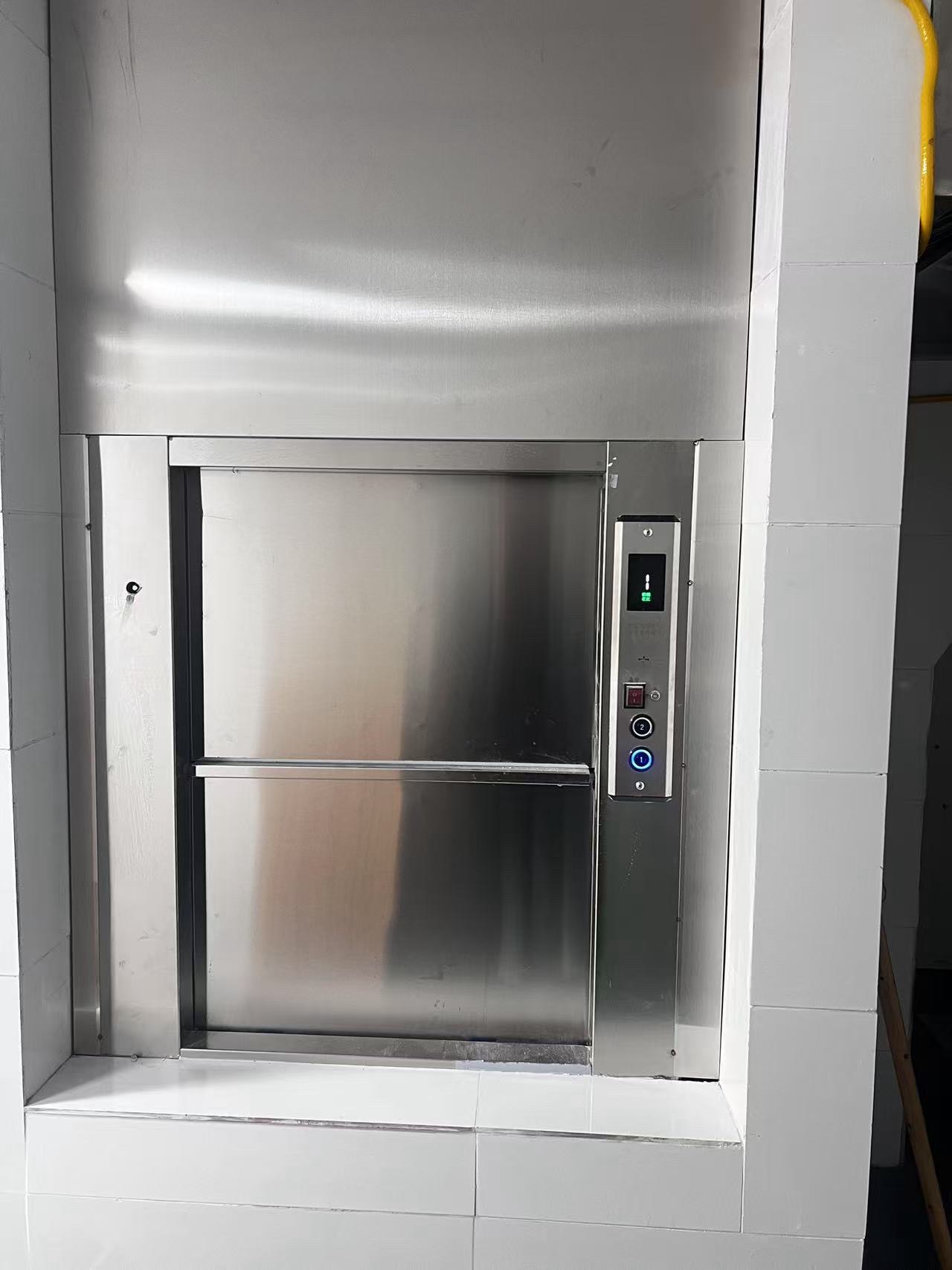 GOELEV dumbwaiter installed on site — stainless steel car with side-mounted call station in tiled wall